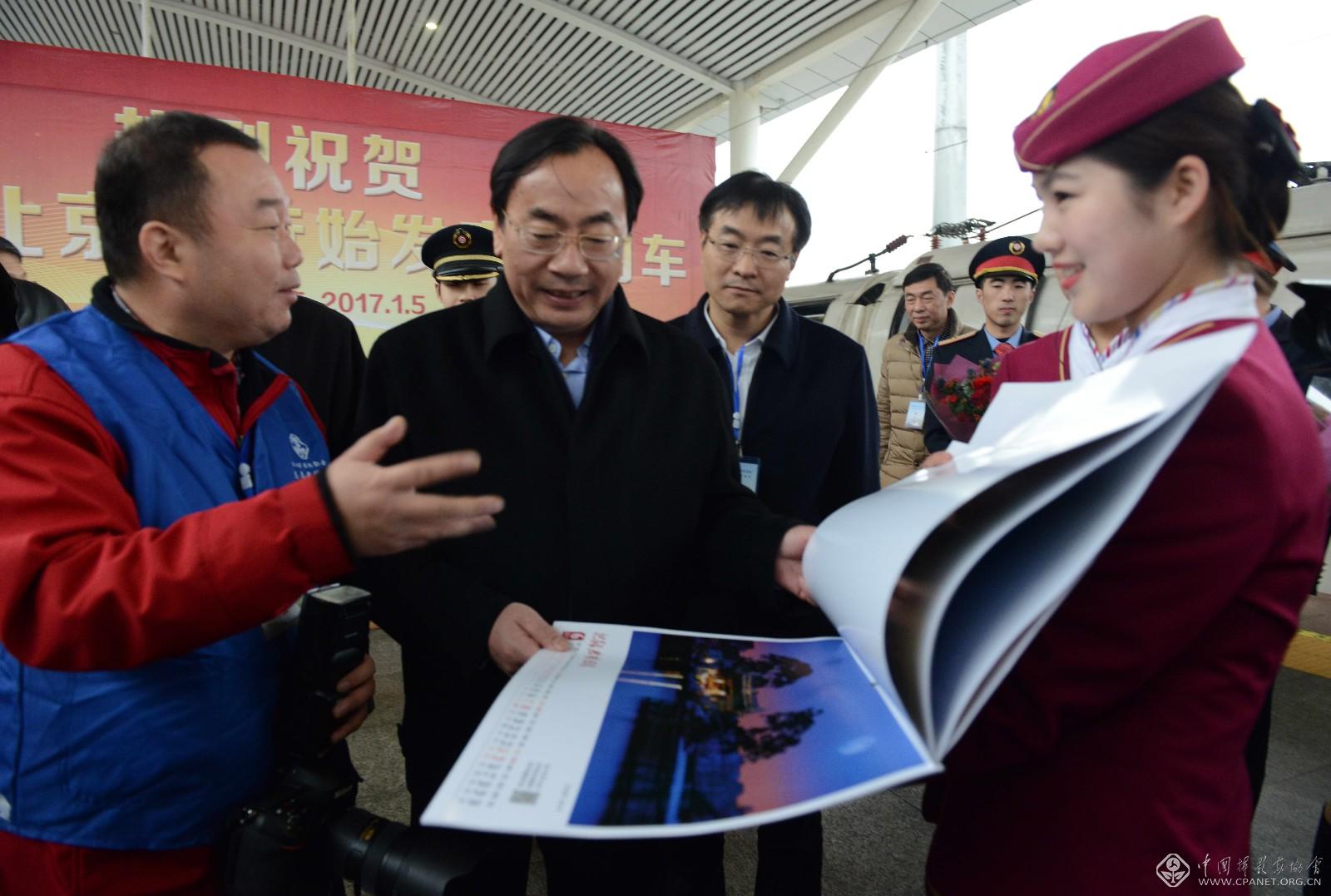 紹興市委副書記、代市長馬衛(wèi)光、紹興市攝影家協(xié)會主席袁云向列車乘務(wù)員介紹紹興美美景.JPG