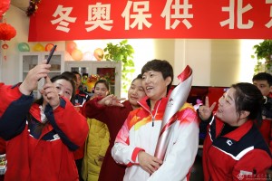 《北京冬奥,我们加油》(组图)  高君摄/北京石油   图4:《我们也光荣》 全国劳动模范吕锦叶(女)光荣担任2022北京冬奥火炬手,参加了2月2日的冬奥火炬传递。2月3日,吕锦叶抱着火炬载誉归来,加油站的姐妹们争相和火炬手合影。