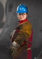 《女焊工》中原油建金属结构厂,工作间隙,一位女焊工自信地回眸闯入镜头。  赵胜强摄/中原设计公司